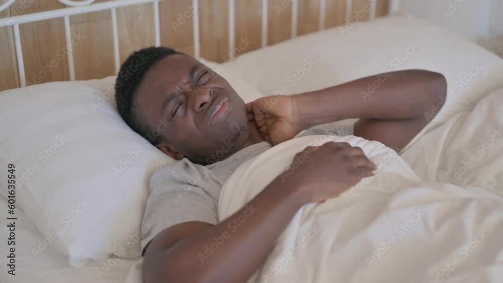 Tired Young African Man with neck Pain Sleeping in Bed Tired Young African Man with neck Pain Sleeping in Bed