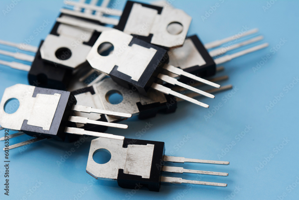 Pile of field-effect transistors on blue surface background. Selective focus Pile of field-effect transistors on blue surface background. Selective focus
