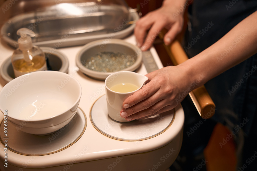 Qualified massotherapist preparing for ayurvedic massage session Qualified massotherapist preparing for ayurvedic massage session