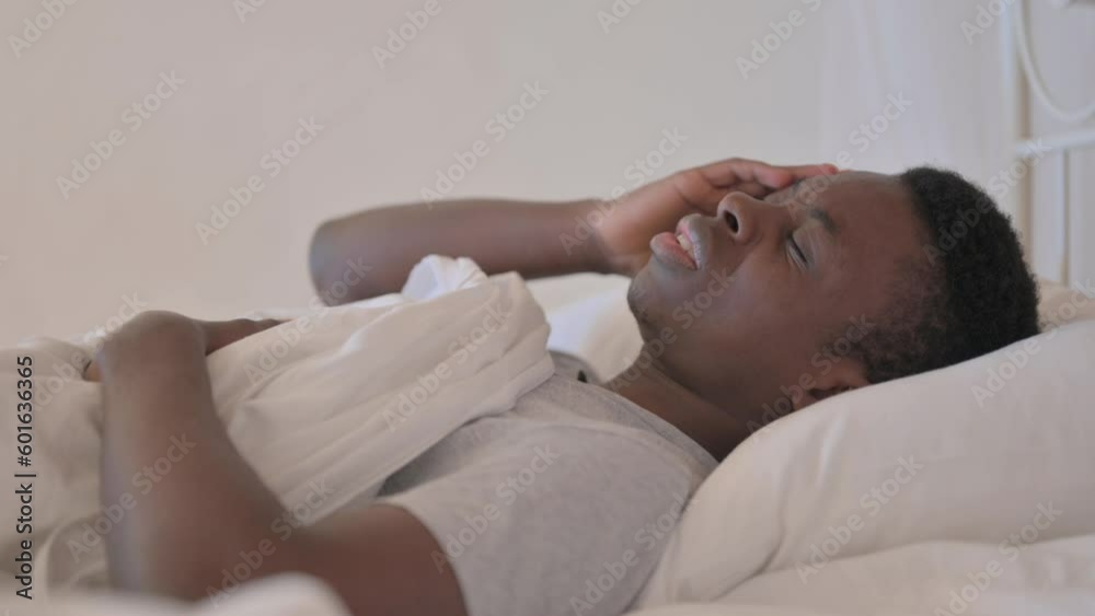 Side View of Young African Man with Headache in Bed Side View of Young African Man with Headache in Bed