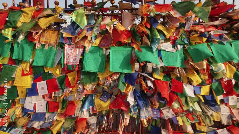 Small colored flags with buddhist symbols and mantras are tied to the fence of the temple