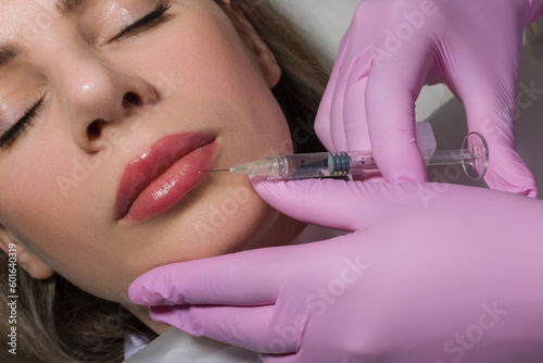 Close up portrait of woman getting botox cosmetic injection in the lips. Beautiful woman gets botox injection in her face. Adult girl gets cosmetic injection of botox in a clinic. Beauty treatments