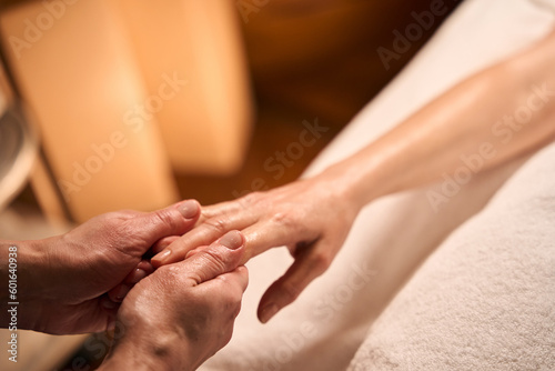 Skilled wellness center masseuse massaging client hand