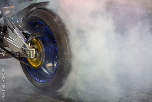 Motorbike burning tire rubber on road, Motorbike wheel drifting and white smoking on track, Motorcycle wheel on racing track with white smoke. photo