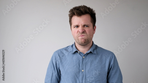 European young man is hesitating and unwilling to make decisions. He is upset about having to do unpleasant work.