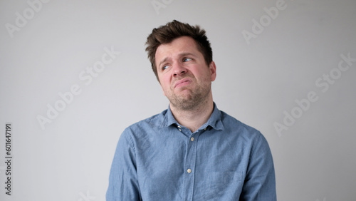 European young man is hesitating and unwilling to make decisions. He is upset about having to do unpleasant work.
