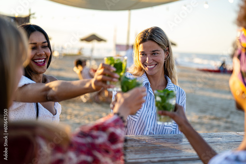 Canvas Print Happy girls having fun drinking cocktails at bar on the beach, summer lifestyle