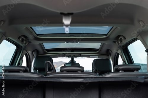 Panoramic glass sun roof in the modern car. Clean sunroof and view at the sky from the inside or car interior. The view from the empty car trunk with rear seats © uflypro
