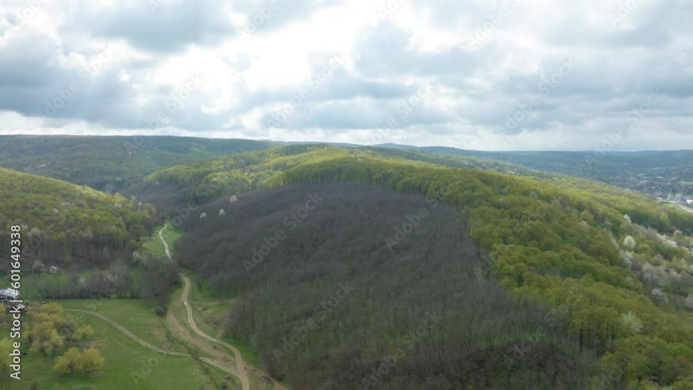 Road Through The Forest With Cloudy Sky And Sunlight Passing On The Mountain Range. - aerial hyperlapse Road Through The Forest With Cloudy Sky And Sunlight Passing On The Mountain Range. - aerial hyperlapse