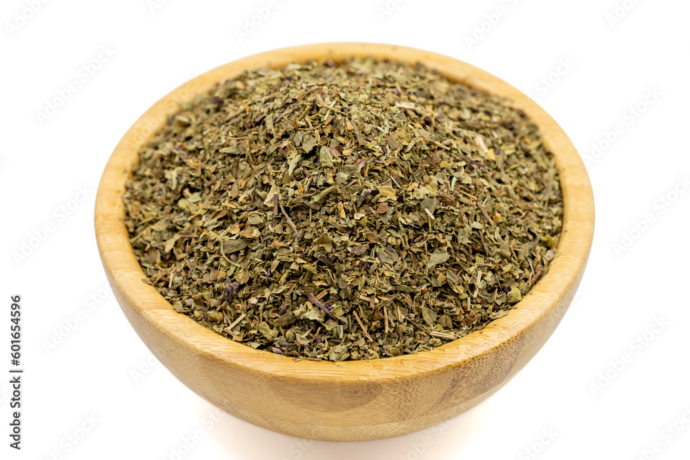 Dried crushed basil isolated on white background. Dried ground basil powder spices in wooden bowl. Spice concept Dried crushed basil isolated on white background. Dried ground basil powder spices in wooden bowl. Spice concept
