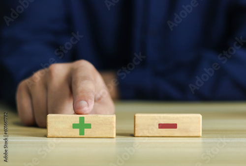 Wooden blocks showing plus and minus signs. The concept of antithesis. Decision making. Positive or negative business choice. Analysis of advantages and disadvantages Comparison 