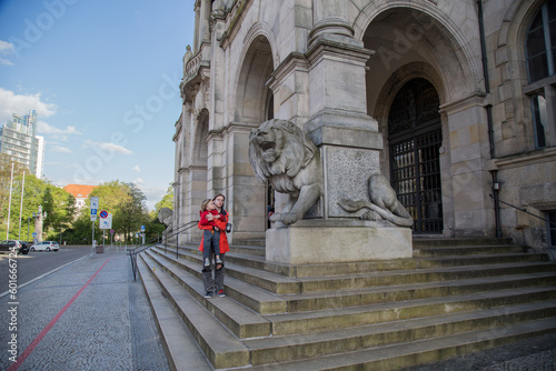 a girl shows her brother a sculpture of a lion at the bottom of the steps to The New Town Hall (German: Neues Rathaus) is a city hall in Hanover