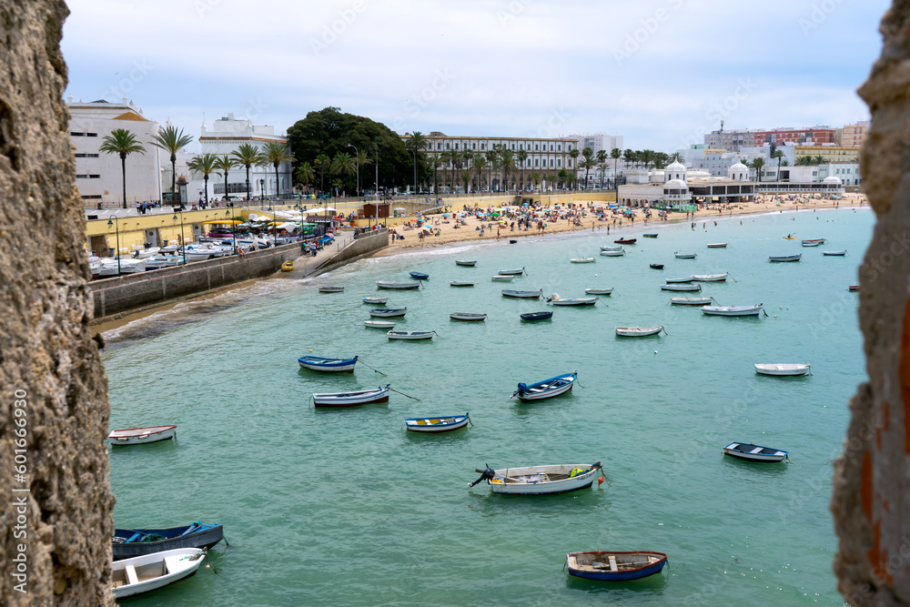 Boats on La Caleta beach located in the historic center of the city in Cadiz, Spain on April 30, 2023
