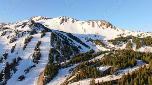 Aerial Cinematic drone early sunrise Spring Mammoth Mountain California ski trails and ski lodge parking lot gondola and chair lift to the left circling movement photo