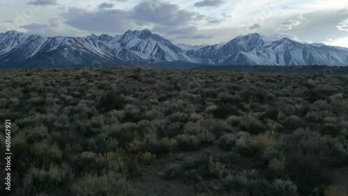 Aerial Cinematic drone Mammoth Lakes California Sierra Nevada  hilltop hot spring field and mountain landscape late after sunset up to the forward pan up reveal movement photo