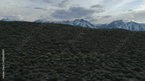 Aerial Cinematic drone Mammoth Lakes California Sierra Nevada  hilltop hot spring field and mountain landscape late after sunset up movement reveal photo