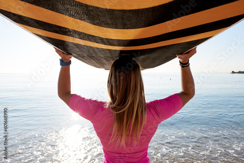 Photography Back view of sportswoman in pink carrying surf.