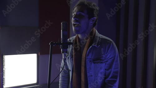 Male singer, singing with passion in the recording studio photo