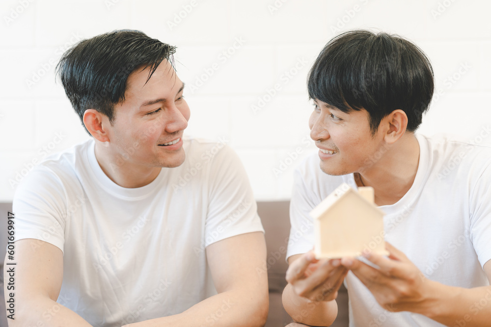 Asian Gay Couple Buying New Dream House Or Property with house model. Concept for marriage, loan, finance, insurance, mortgage, real estate and property. Asian Gay Couple Buying New Dream House Or Property with house model. Concept for marriage, loan, finance, insurance, mortgage, real estate and property.