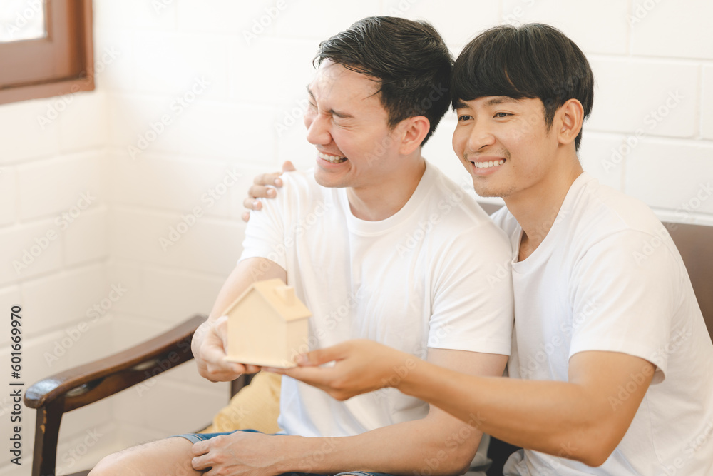 Asian Gay Couple Buying New Dream House Or Property with house model. Concept for marriage, loan, finance, insurance, mortgage, real estate and property. Asian Gay Couple Buying New Dream House Or Property with house model. Concept for marriage, loan, finance, insurance, mortgage, real estate and property.