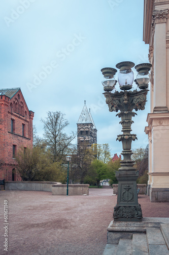 Historic lamp post with the steeples of Lund cathedral visible in the background during morning in Sweden photo