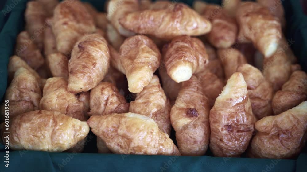 Pile of freshly baked crisp mini croissants in basket with green cloth. Pile of freshly baked crisp mini croissants in basket with green cloth.