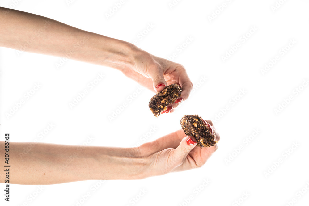 Healthy granola bar (muesli or cereal bar) isolated on white background. Muesli bar in females hands with red manicure.