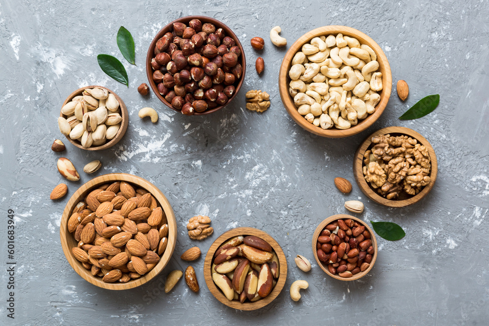 mixed nuts in wooden bowl. Mix of various nuts on colored background. pistachios, cashews, walnuts, hazelnuts, peanuts and brazil nuts mixed nuts in wooden bowl. Mix of various nuts on colored background. pistachios, cashews, walnuts, hazelnuts, peanuts and brazil nuts