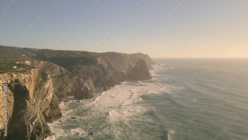 Cliffs And Ocean, Praia da Adraga In Portugal At Sunset - aerial drone shot Cliffs And Ocean, Praia da Adraga In Portugal At Sunset - aerial drone shot