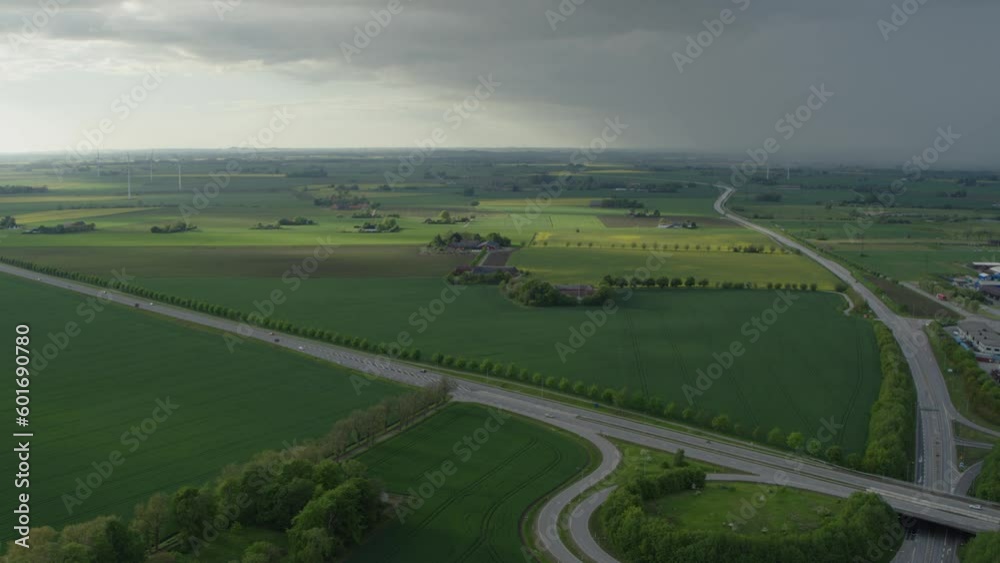Road Through Rural Fields Going To Lund City In Skane, Sweden On A Cloudy Day. wide aerial