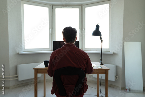 Young man working at the computer. Distance working, online education or shoping