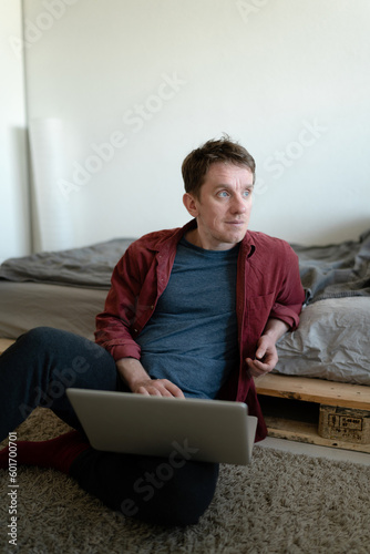 young man sitting and typing on laptop, distant work