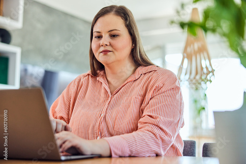 A serious curvy businesswoman working on a new project on a laptop at home.