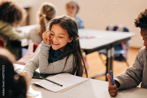 Billede på lærred Small girl laughs happily in a primary school class