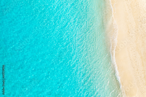 Top drone view travel landscape. Summer sunrise seascape waves, blue sea water yellow sand. Aerial amazing tropical nature background. Beautiful bright sea waves splashing and beach sand sunset light