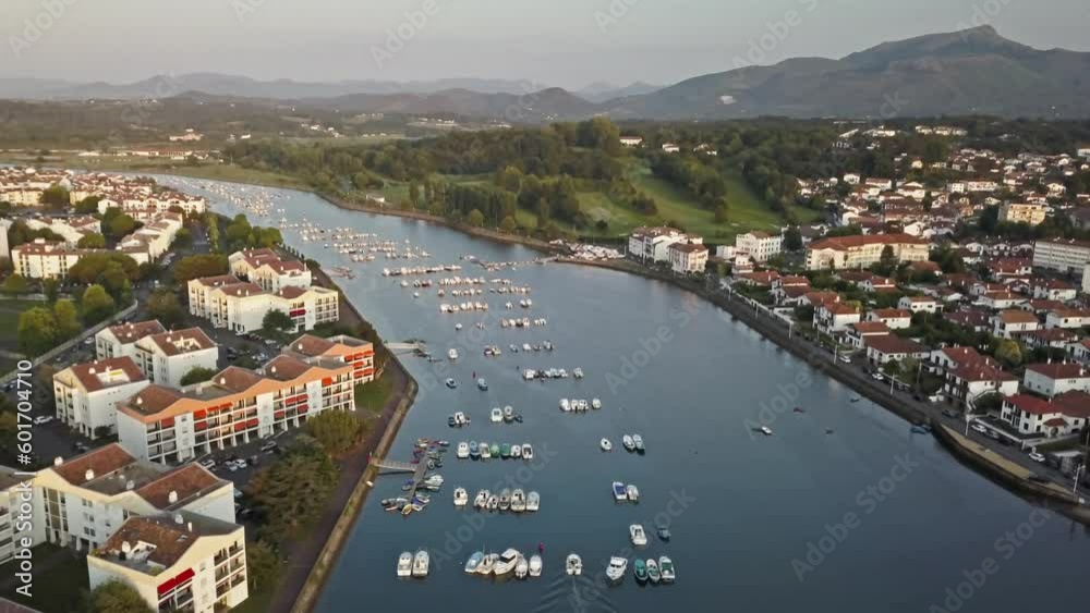 Rising aerial overview of fishing boats docked or anchored in the middle of river in saint jean de luz Rising aerial overview of fishing boats docked or anchored in the middle of river in saint jean de luz
