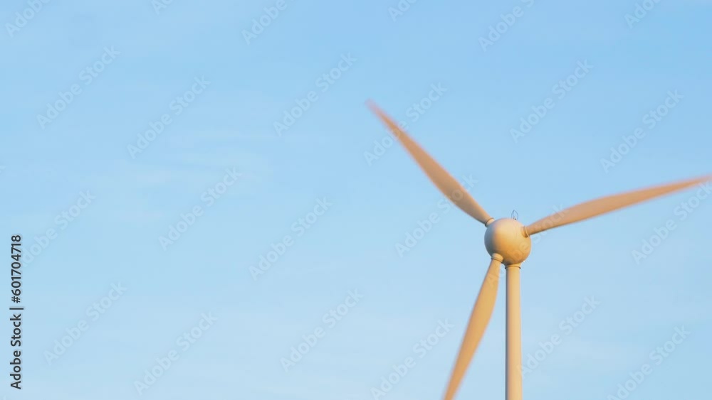 Beautiful view of wind turbine generating renewable energy in the wind farm, green countryside landscape, vibrant sunny spring evening with golden hour light, distant medium shot Beautiful view of wind turbine generating renewable energy in the wind farm, green countryside landscape, vibrant sunny spring evening with golden hour light, distant medium shot