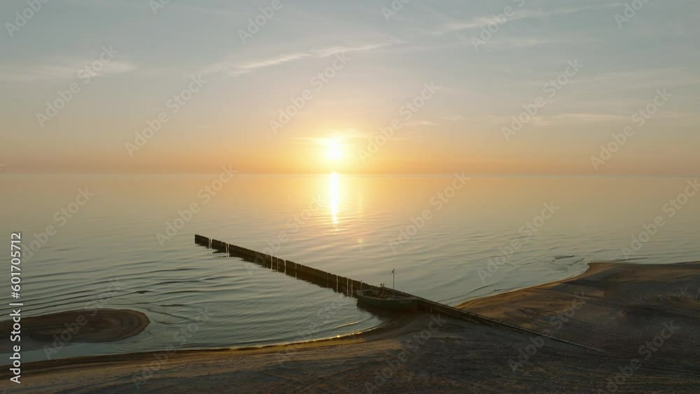 Establishing aerial view of Baltic sea coast, old wooden pier, calm evening with vibrant sunset, romantic golden hour light, white sand beach, wide drone shot moving forward Establishing aerial view of Baltic sea coast, old wooden pier, calm evening with vibrant sunset, romantic golden hour light, white sand beach, wide drone shot moving forward