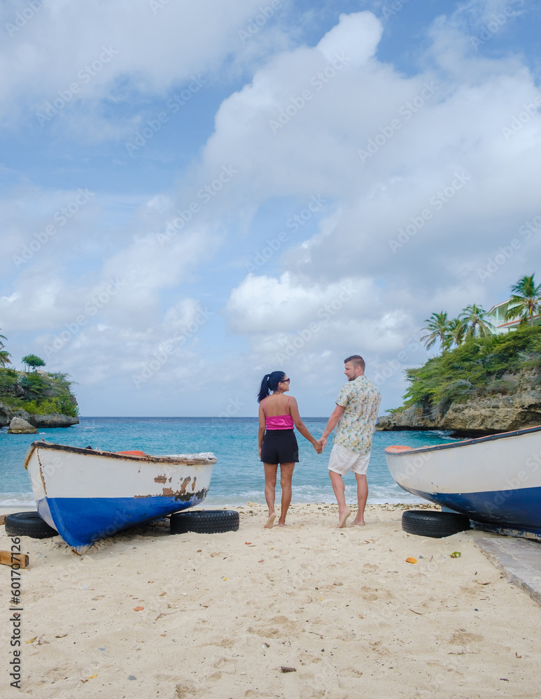 A couple of men and women in swimshorts and bikinis at Playa Lagun Beach Cliff Curacao, Lagun Beach Curacao a small island in the Caribbean. A couple of men and women in swimshorts and bikinis at Playa Lagun Beach Cliff Curacao, Lagun Beach Curacao a small island in the Caribbean.