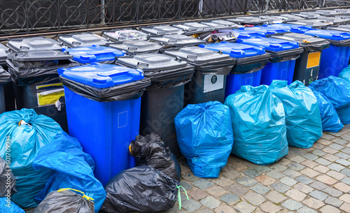 Black and blue trash cans and garbage bags