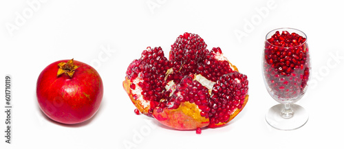 A glass of pomegranate seeds and pomegranate fruit