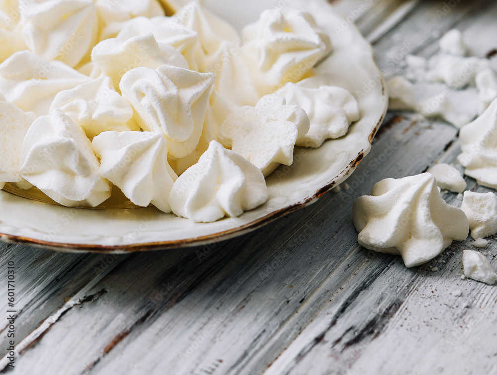 Meringue cookies in in a plate on wood Meringue cookies in in a plate on wood