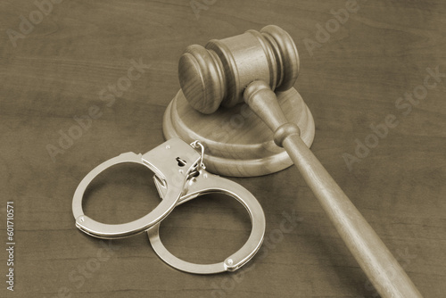Handcuffs an wooden gavel on table. Court and punishing concept.