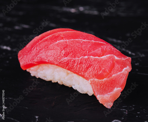One tuna sushi on black stone background