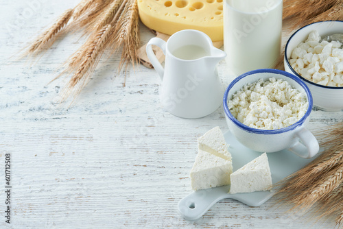 Shavuot jewish holiday celebration. Kosher fresh dairy products milk and cheese, ripe wheat, cream on white wooden background. Dairy products over white wooden background. Shavuot concept. Top view.