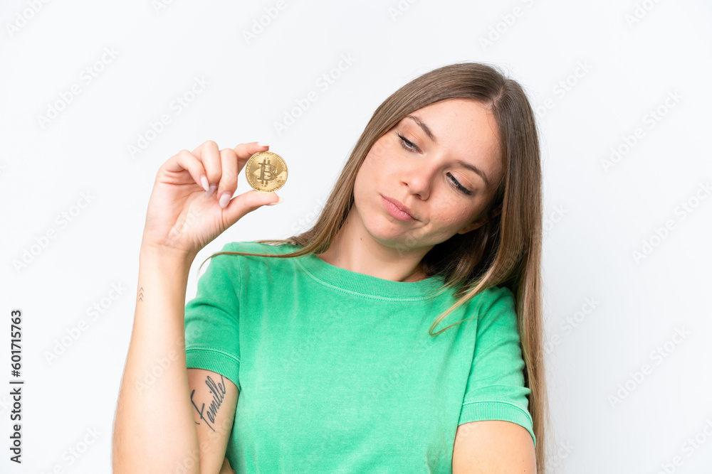Young beautiful blonde woman holding a Bitcoin isolated on white background with sad expression Young beautiful blonde woman holding a Bitcoin isolated on white background with sad expression