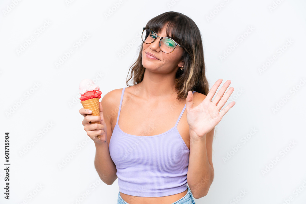 Young caucasian woman with a cornet ice cream over isolated white background saluting with hand with happy expression Young caucasian woman with a cornet ice cream over isolated white background saluting with hand with happy expression