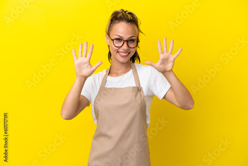 Restaurant waiter Russian girl isolated on yellow background counting ten with fingers