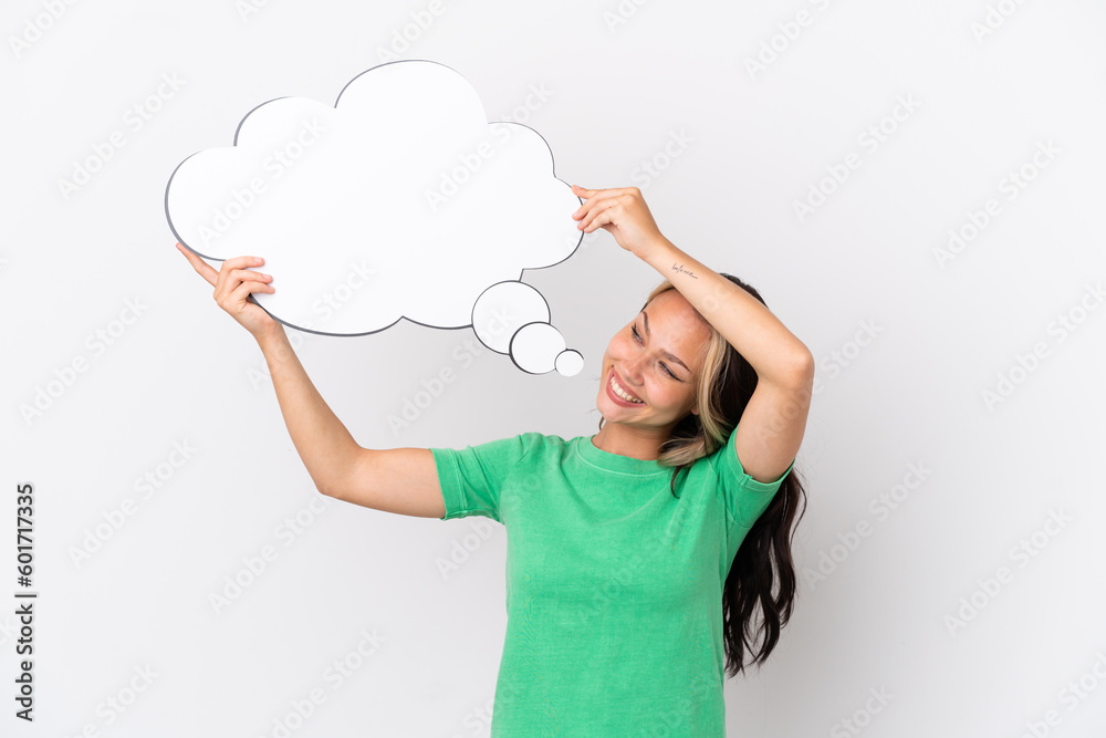 Teenager Russian girl isolated on blue background holding a thinking speech bubble Teenager Russian girl isolated on blue background holding a thinking speech bubble