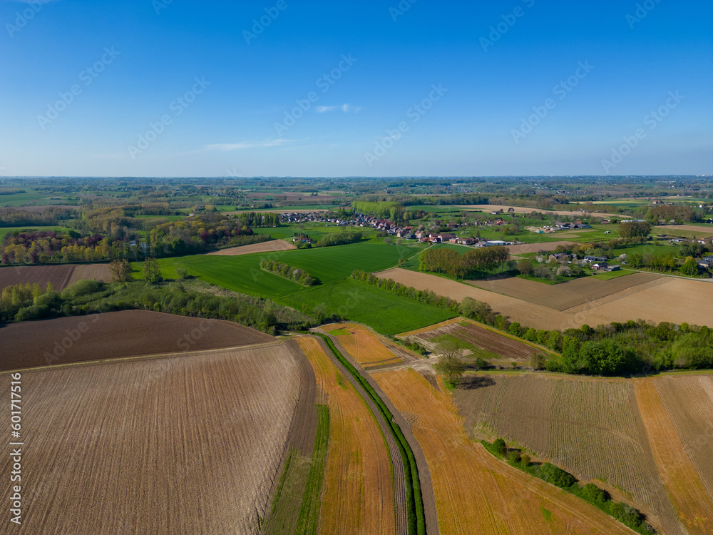 Fantastic colorful aerial photography of green wavy field in sunny day. Top view drone shot. Agricultural area of Belgium, Europe. Concept photo of agrarian industry. Artistic wallpaper. Beauty of